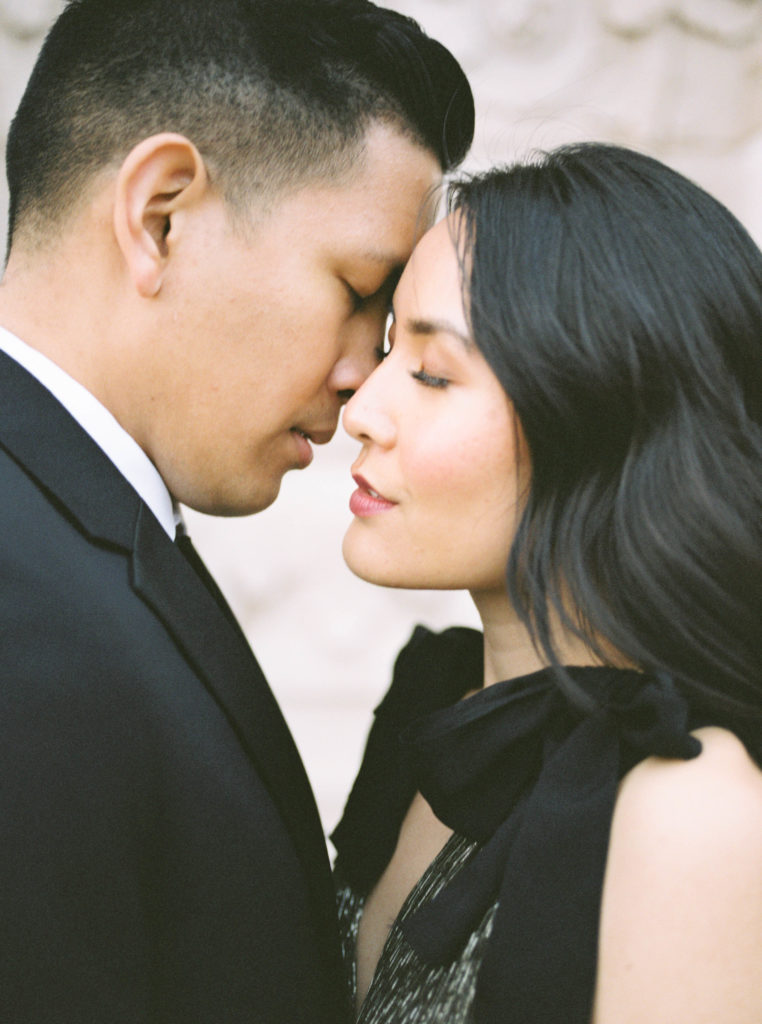 Fine art stylish and chic engagement session with beautiful architecture and Revolve dress and black suit at Balboa Park in San Diego by destination wedding photographer Liz Andolina