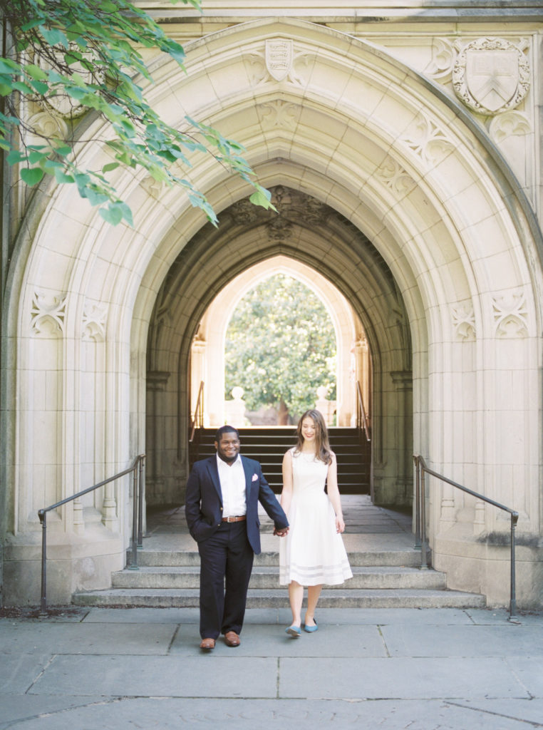 Engaged couple walking through Rockefeller College on Princeton University Campus