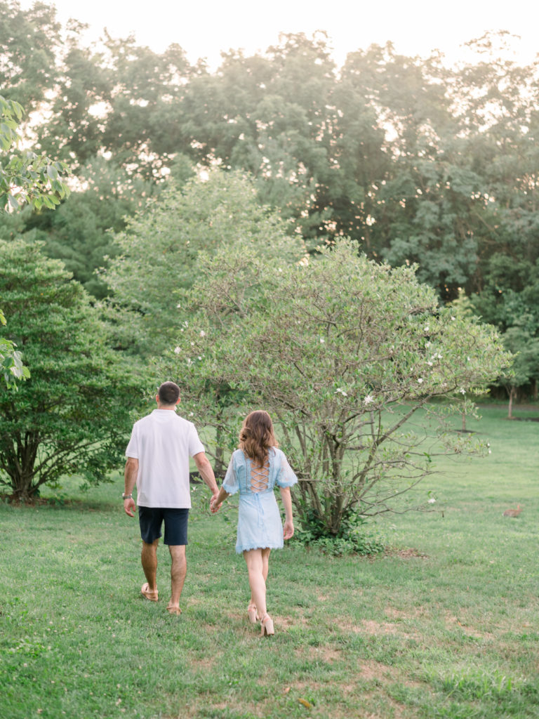 Couple walking in old field during their engagement session at Sayen House & Gardens by Liz Andolina Photography