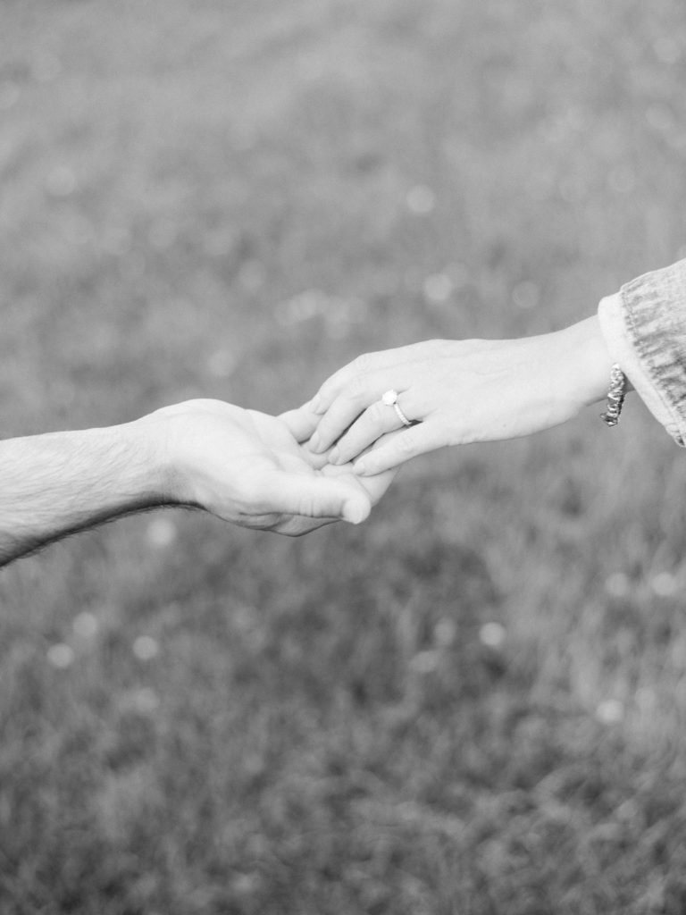 Couple holds hands to show off engagement ring at engagement session at Sayen House & Gardens by Liz Andolina Photography