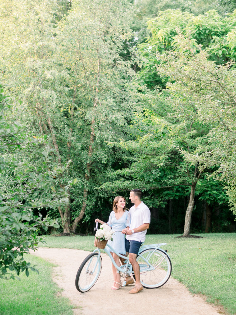 Couple sit on vintage bike at their engagement session at Sayen House & Gardens by Liz Andolina Photography
