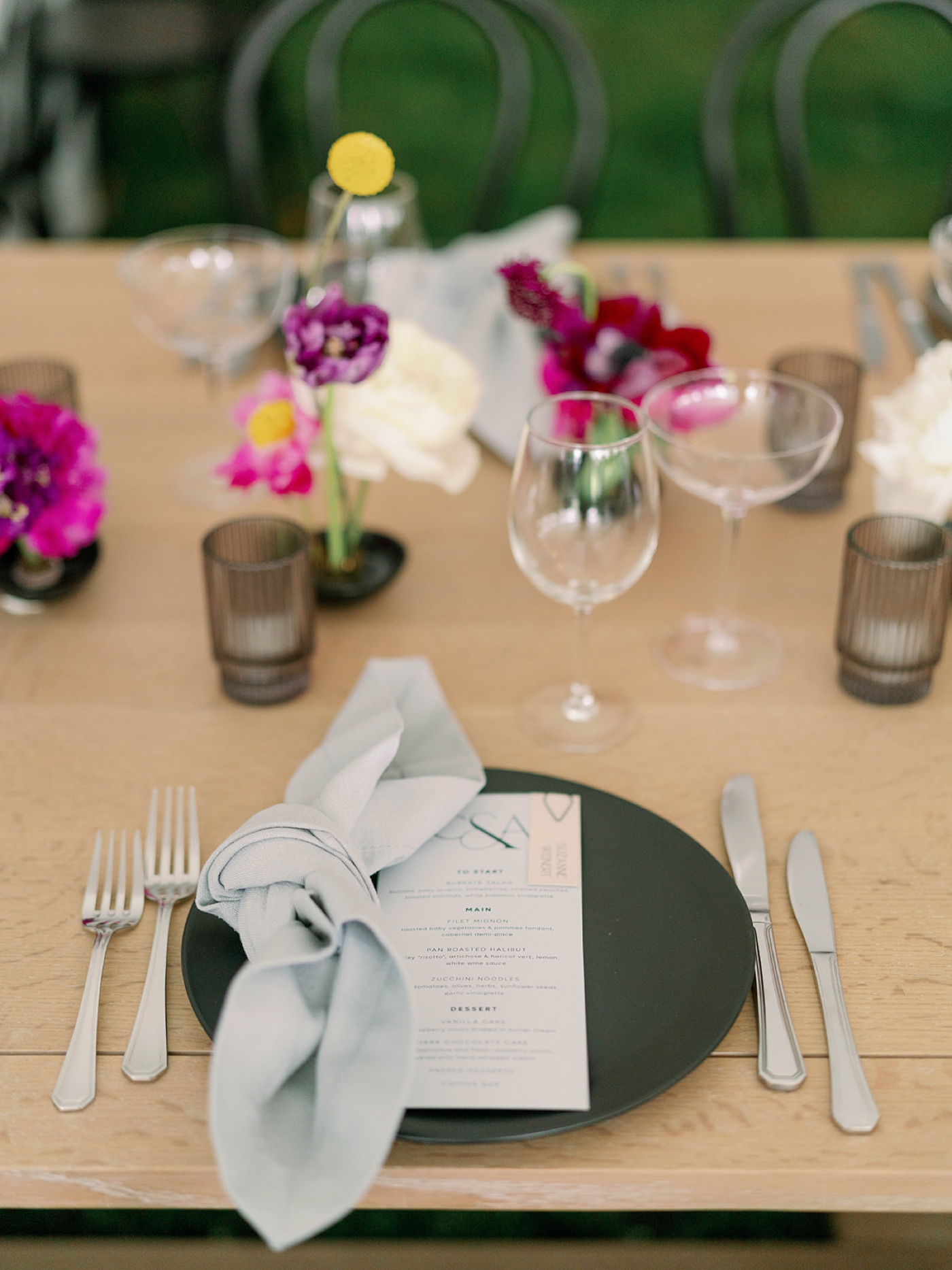 Table setting with a matte green charger plate and a dove grey linen napkin