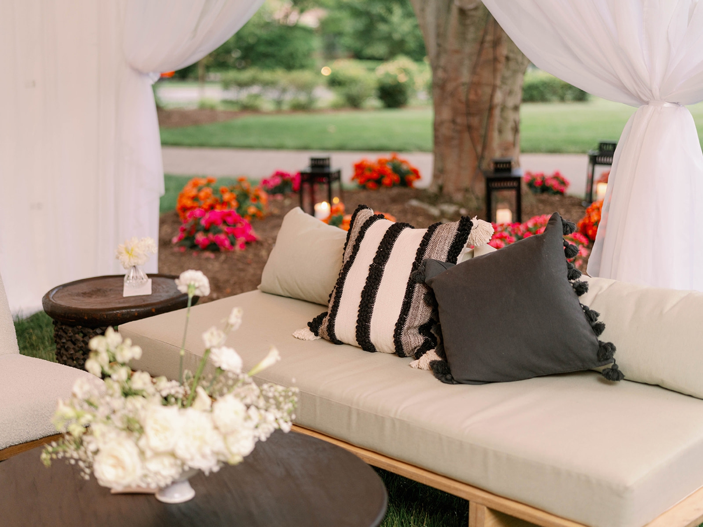 Seating lounge with throw pillows, a coffee table, and white flowers in a vase