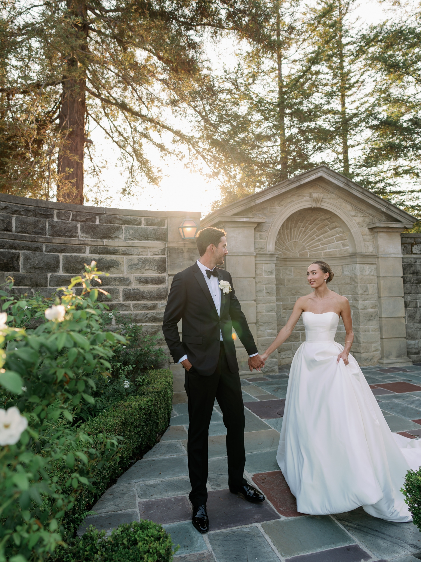 Bride and groom walking hand in hand through the grounds at the Greyview Mansion 