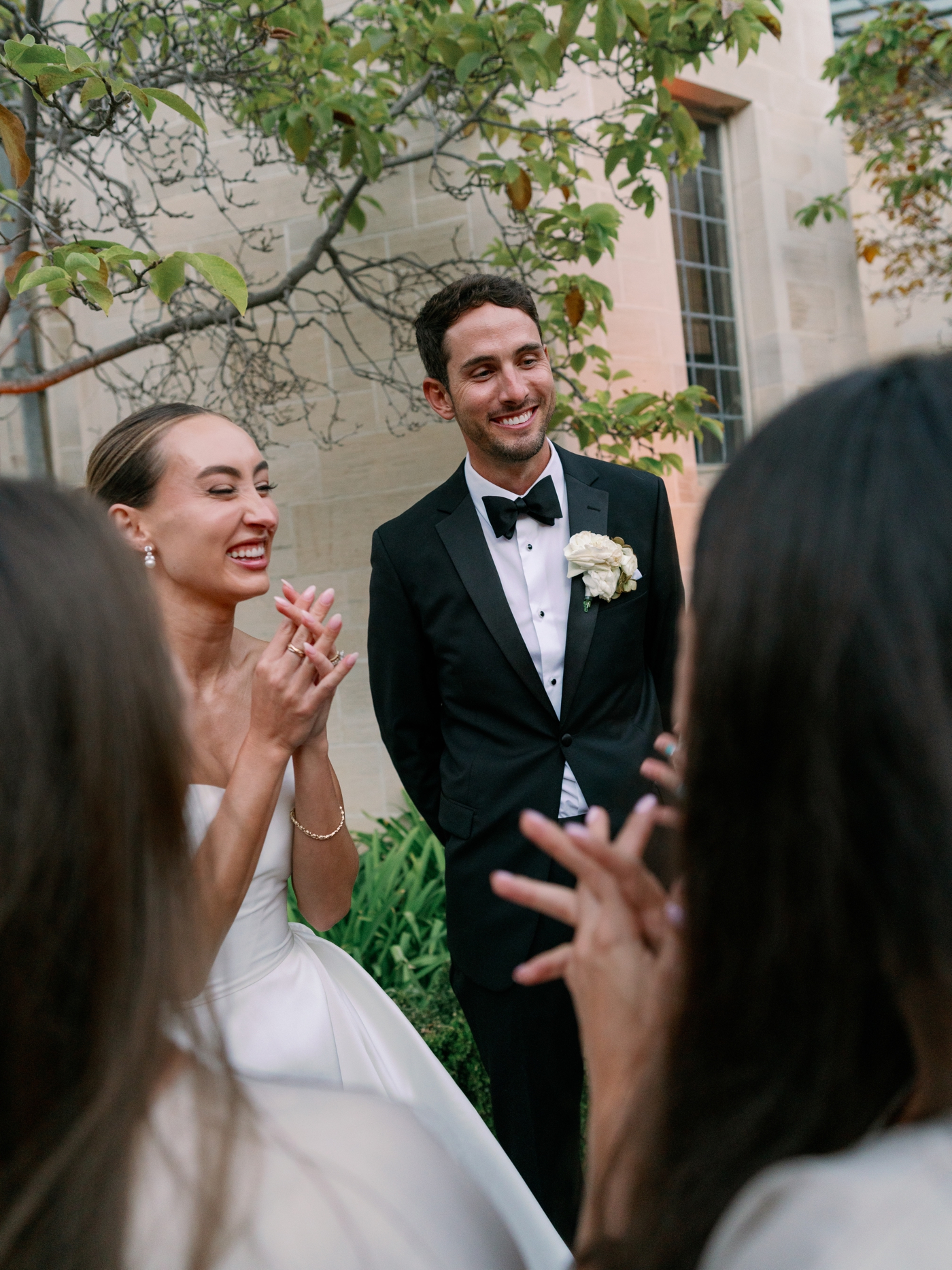 Bride and groom laughing and talking with guests