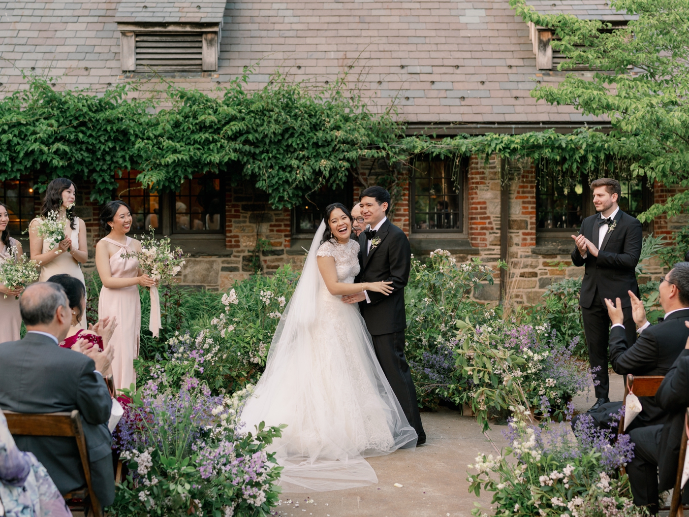 Bride and groom holding each other and laughing during wedding ceremony at Blue Hill Farm 