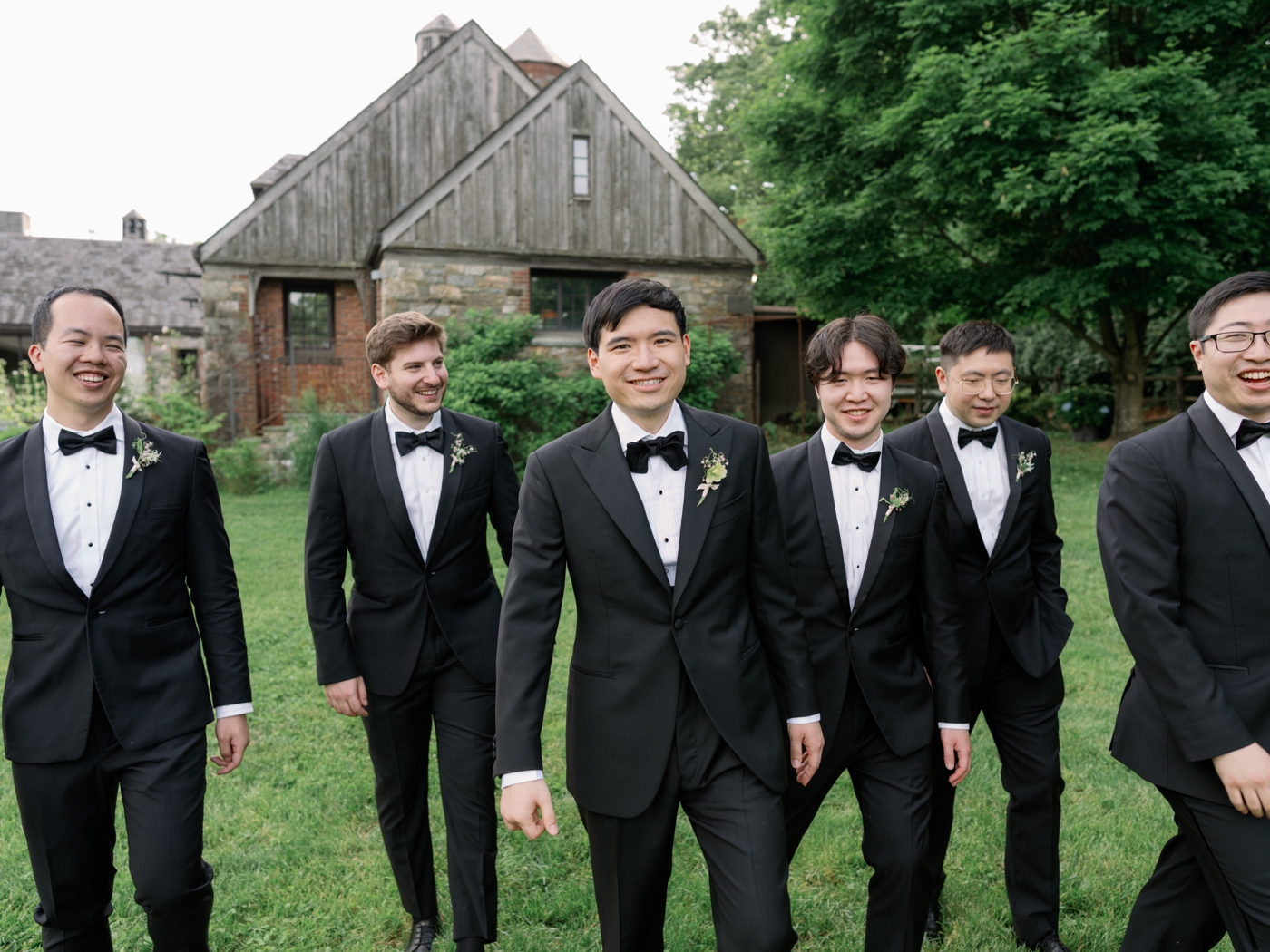 Groom and groomsmen smiling and walking towards camera